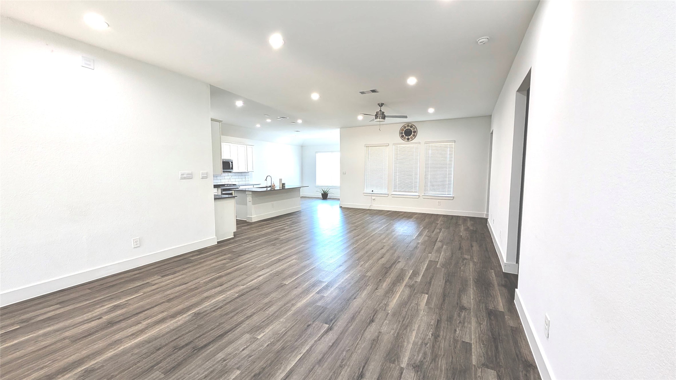 13760 Rising Sun Lane Conroe, TX 77384 - Photo 19 of 43 a view of an empty room and kitchen with wooden floor