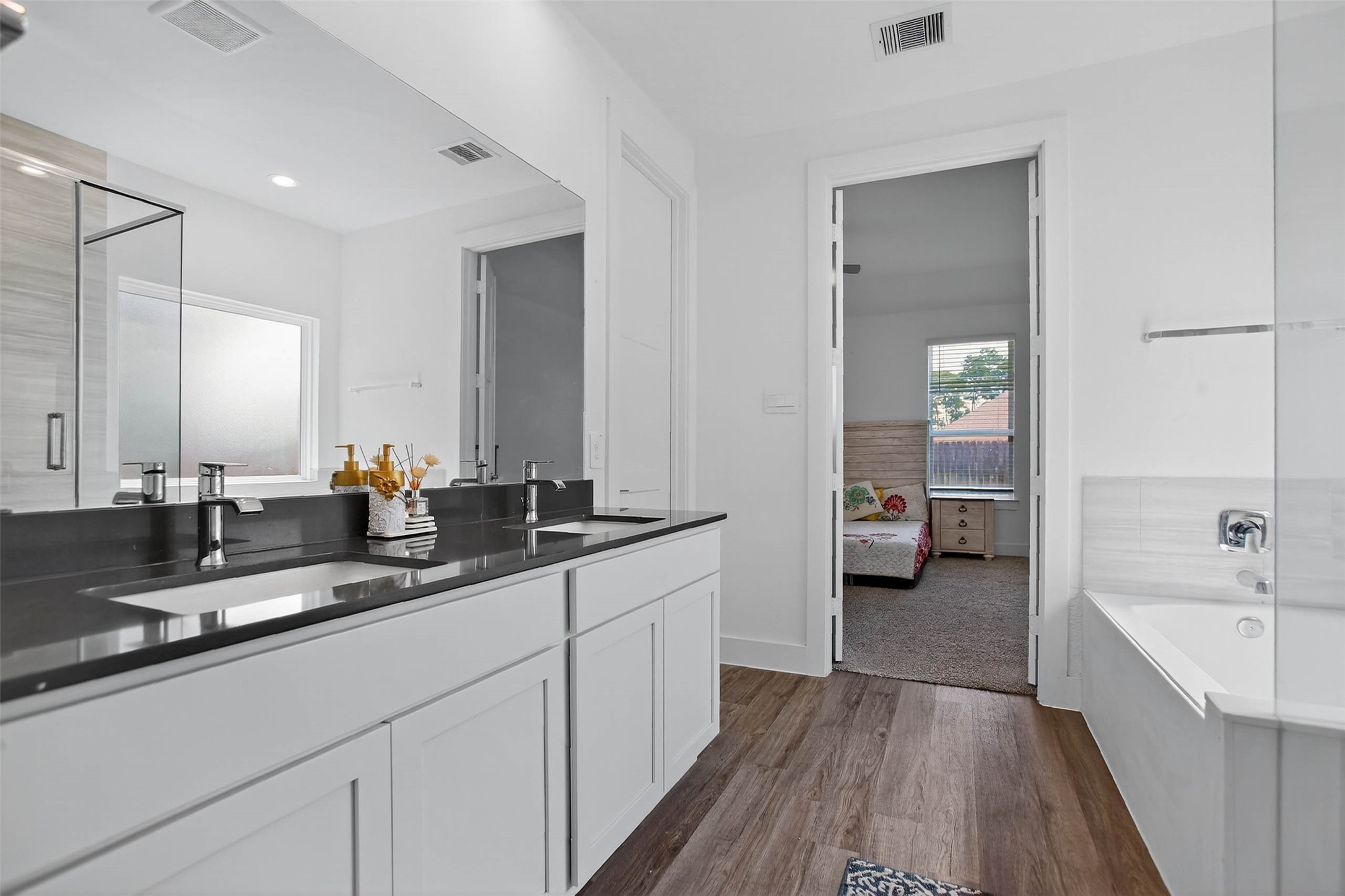 13760 Rising Sun Lane Conroe, TX 77384 - Photo 32 of 43 a en suite bathroom with a double vanity sink a mirror and a bathtub