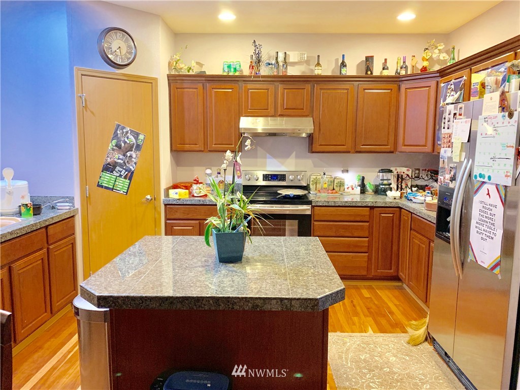 2969 South 296th Street Federal Way, WA 98003 - Photo 3 of 5 a kitchen with stainless steel appliances granite countertop a sink a stove a dining table and chairs