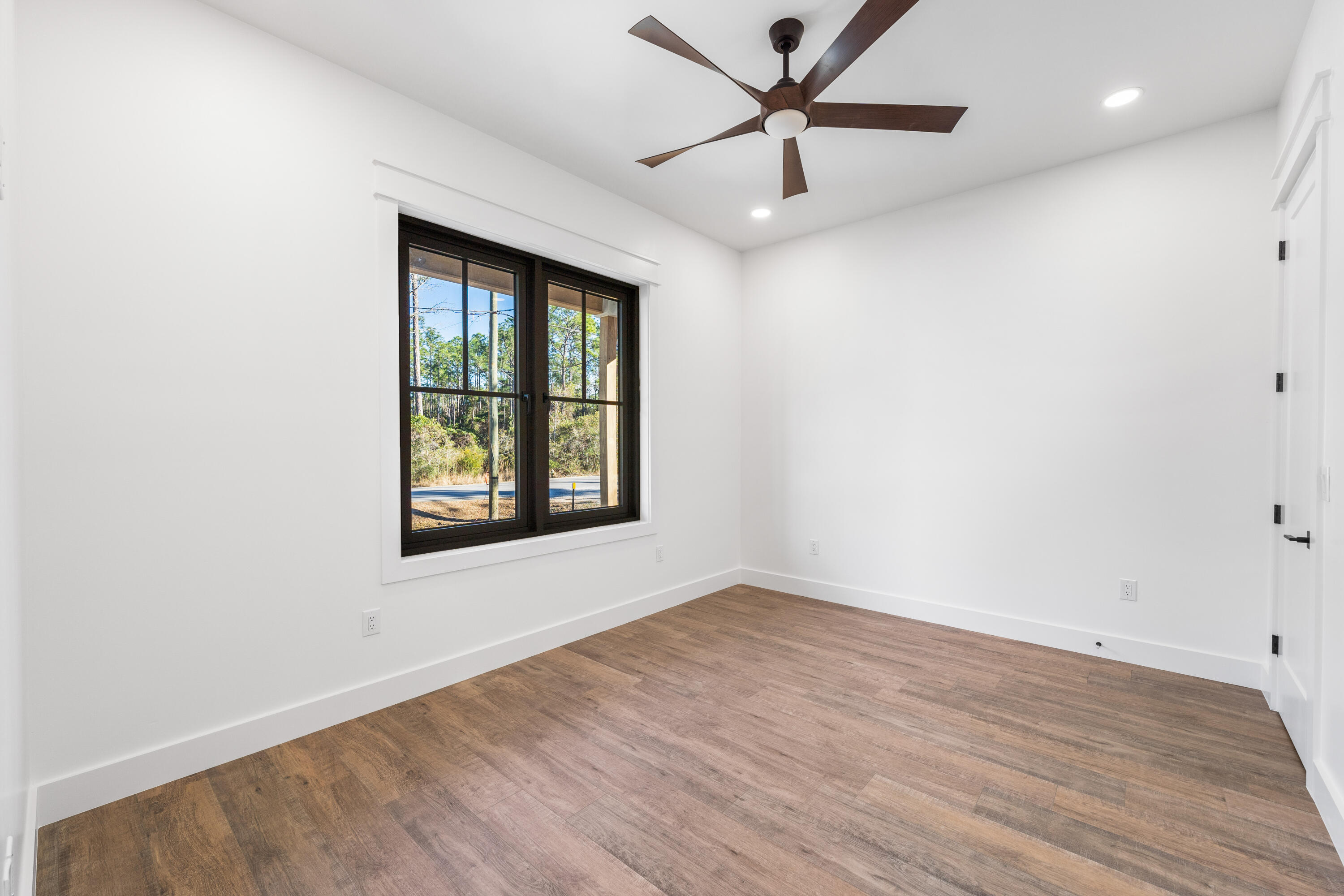 783 Indian Woman Road Santa Rosa Beach, FL 32459 - Photo 26 of 33 an empty room with wooden floor fan and windows