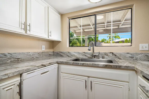 a kitchen with granite countertop a stove and a sink