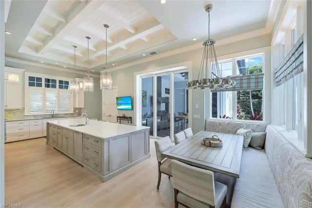 a large white kitchen with a large window and white cabinets