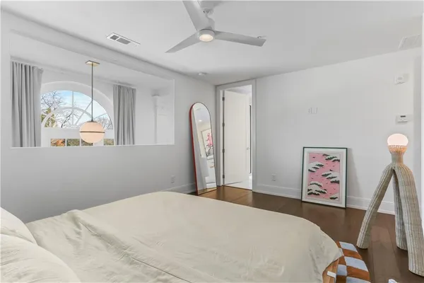 a bedroom with a large bed and a chandelier