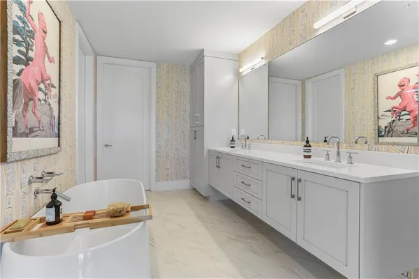a bathroom with a double vanity sink mirror and bathtub