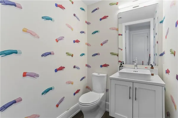 a bathroom with a sink vanity mirror and toilet