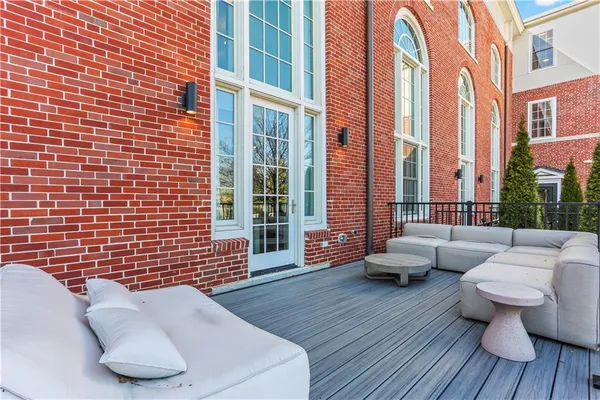 a view of sitting area on roof deck with wooden floor and fence
