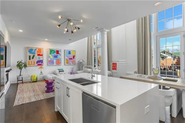 a room with kitchen island a sink and a chandelier