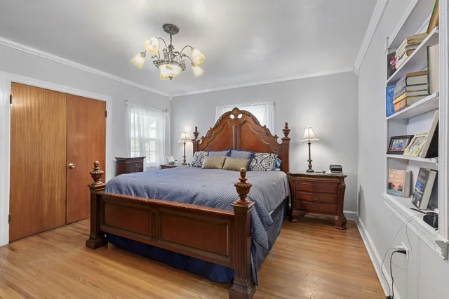 a bedroom with bed and a chandelier