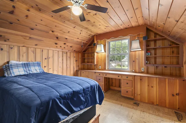 a bed sitting in a spacious bedroom next to a window