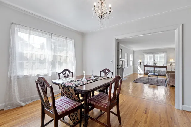 a dining room with furniture a chandelier and wooden floor