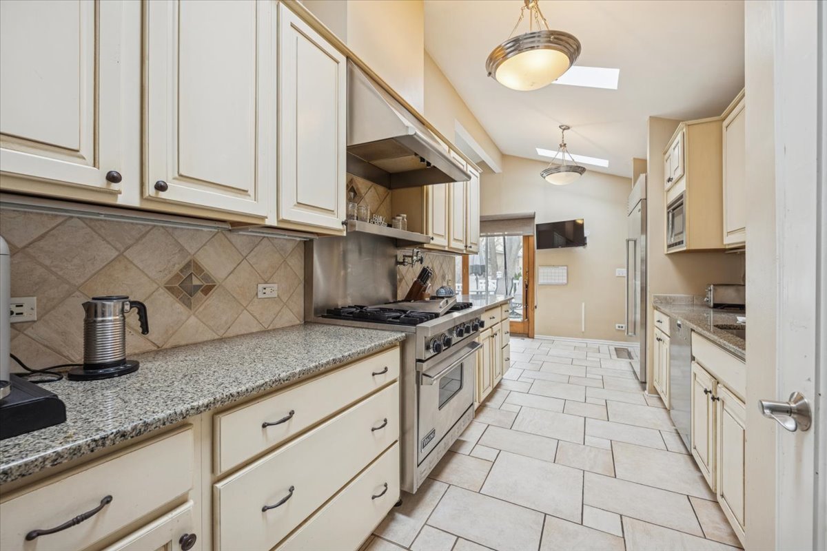 1908 McCraren Road Highland Park, IL 60035 - Photo 10 of 37 a kitchen with granite countertop a stove a sink and a white cabinets