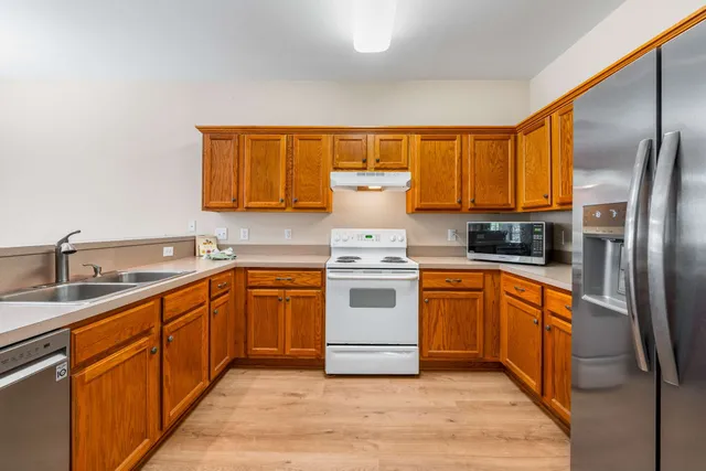 a kitchen with stainless steel appliances granite countertop a stove a sink and a refrigerator