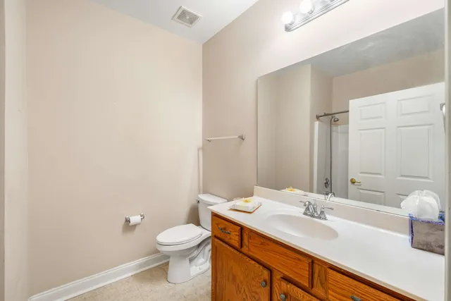 a bathroom with a granite countertop sink toilet and mirror