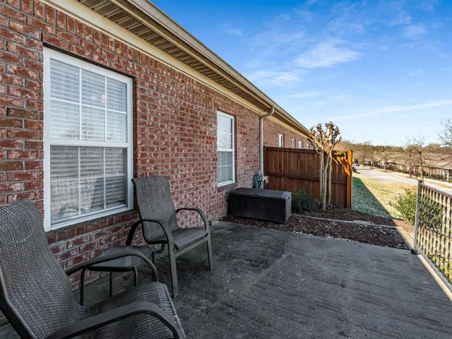 a view of a patio with table and chairs with wooden floor and fence