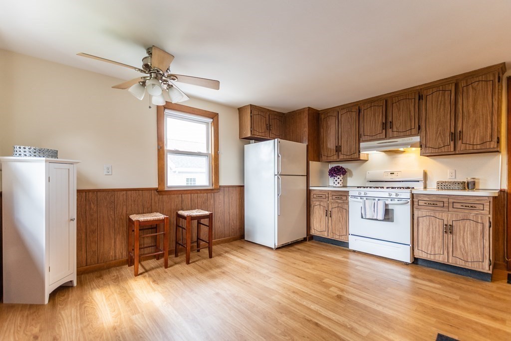 57 Cook Street Newton, MA 02458 - Photo 14 of 28 a kitchen with a refrigerator a microwave a dining table and chairs