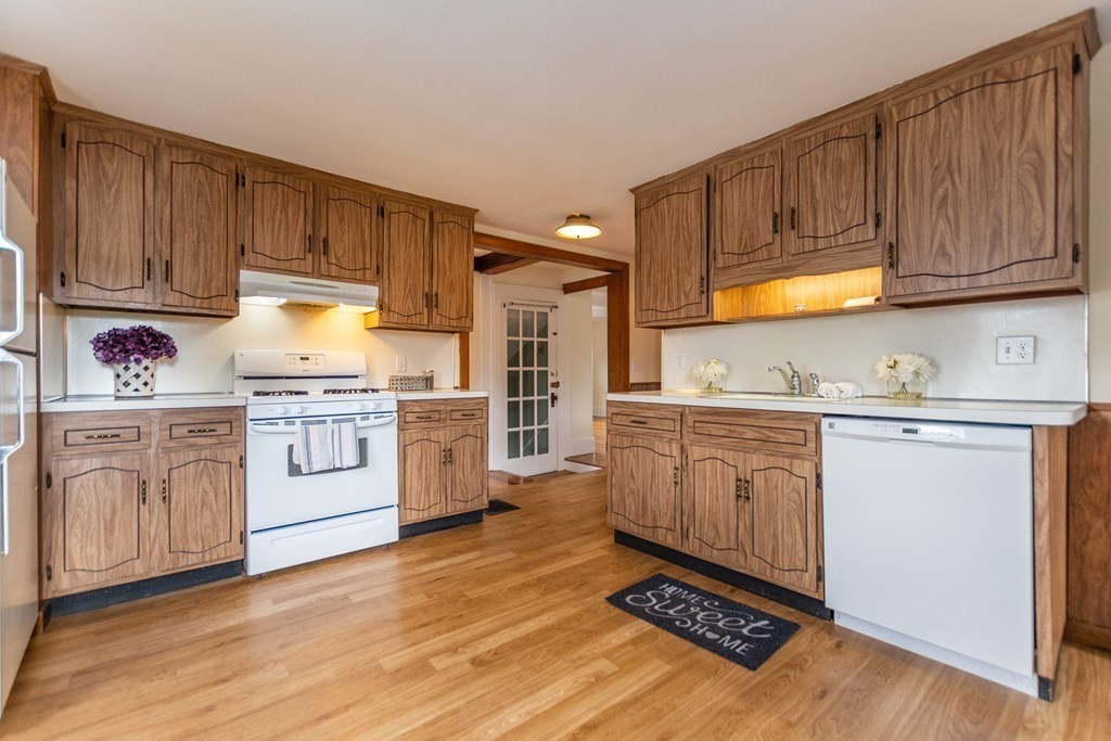 57 Cook Street Newton, MA 02458 - Photo 15 of 28 a kitchen with granite countertop wooden cabinets and white appliances