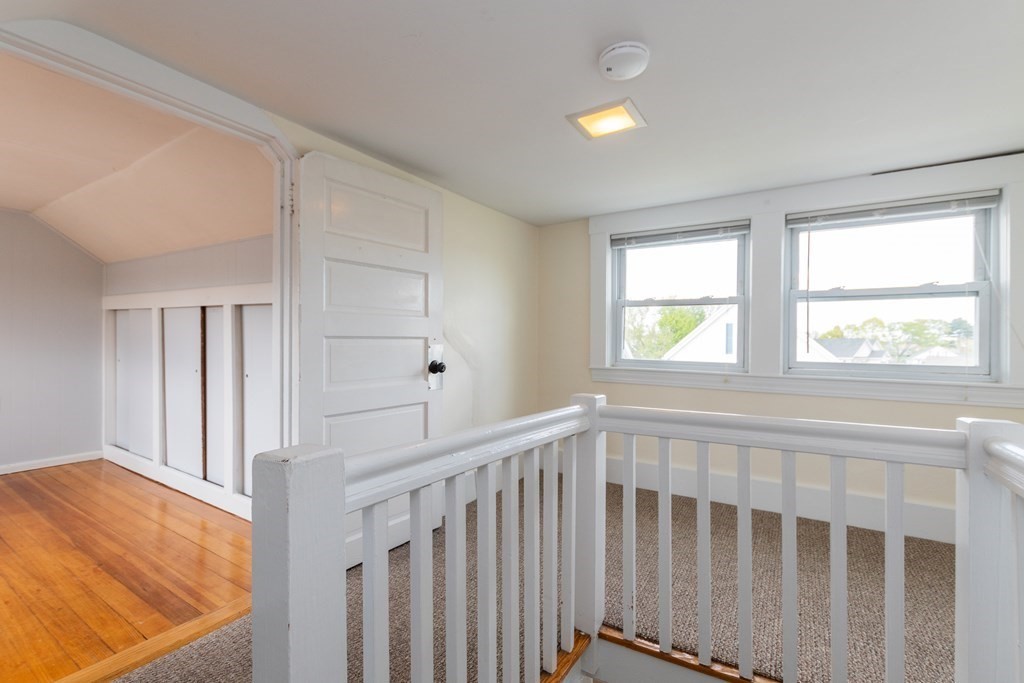 57 Cook Street Newton, MA 02458 - Photo 25 of 28 a view of hallway with wooden floor and chandelier