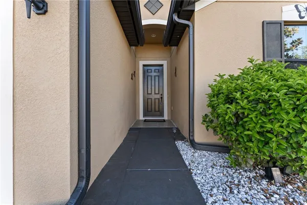 a hallway with potted plants in front of door