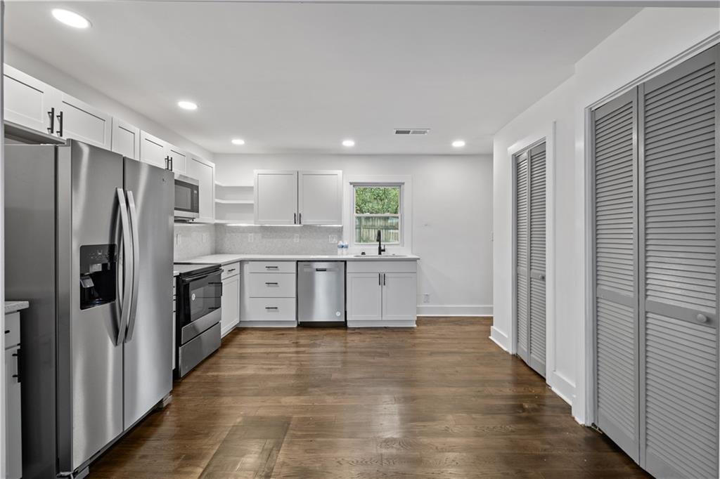 a large kitchen with cabinets and stainless steel appliances
