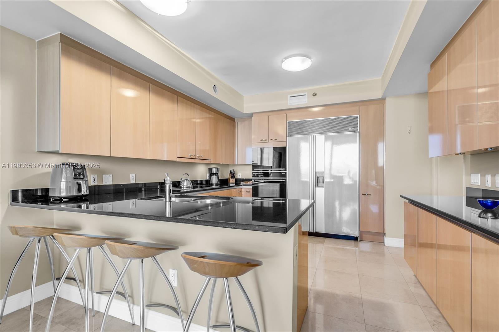 791 Crandon Boulevard, Unit 1402 Key Biscayne, FL 33149 - Photo 15 of 56 a kitchen with stainless steel appliances granite countertop a sink a stove a refrigerator cabinets and chairs