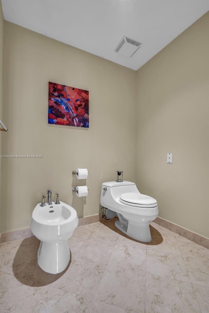 791 Crandon Boulevard, Unit 1402 Key Biscayne, FL 33149 - Photo 24 of 56 a white toilet sitting next to a bathroom sink