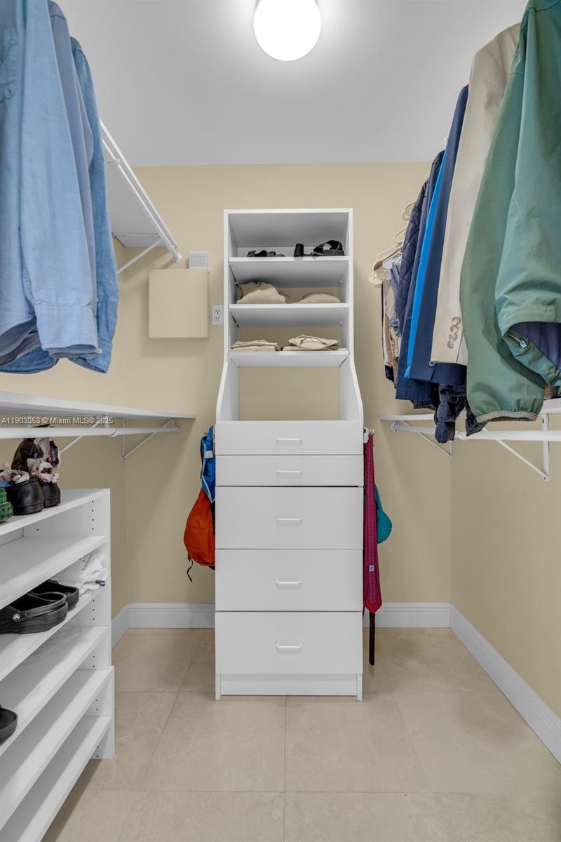 791 Crandon Boulevard, Unit 1402 Key Biscayne, FL 33149 - Photo 25 of 56 a view of walk in closet with clothes and shoes