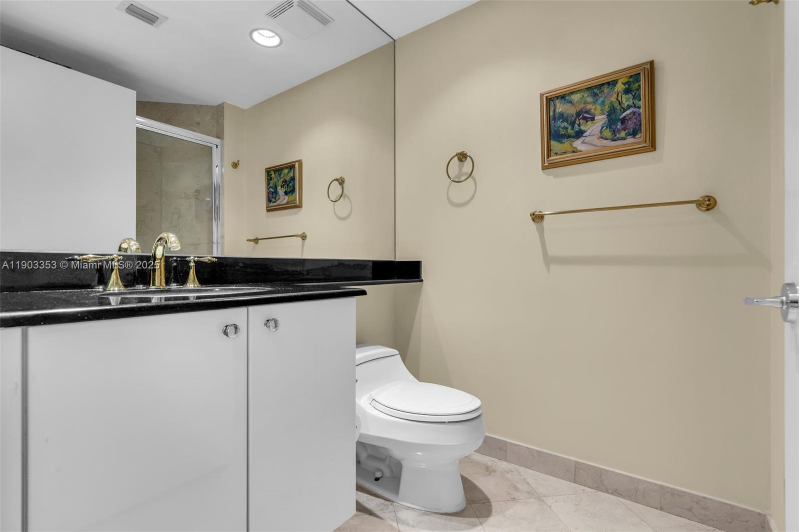 791 Crandon Boulevard, Unit 1402 Key Biscayne, FL 33149 - Photo 28 of 56 a bathroom with a granite countertop sink mirror vanity and toilet