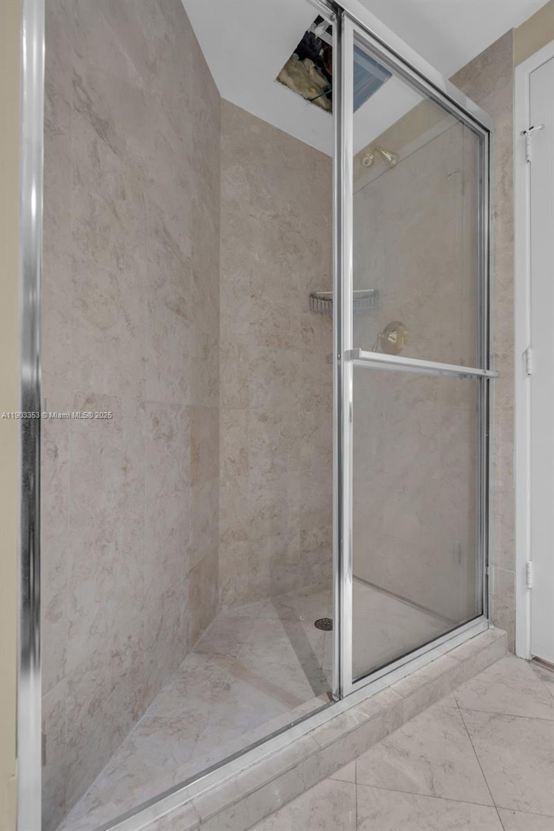791 Crandon Boulevard, Unit 1402 Key Biscayne, FL 33149 - Photo 29 of 56 a bathroom with a glass shower door
