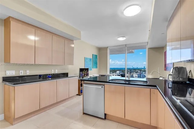 a large kitchen with stainless steel appliances granite countertop a lot of counter space and a sink
