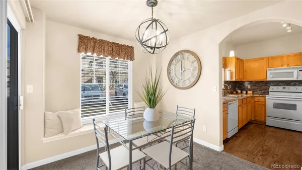 a dining room with furniture a chandelier and wooden floor