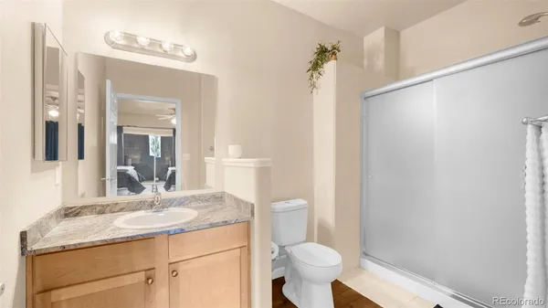 a bathroom with a granite countertop sink toilet and shower