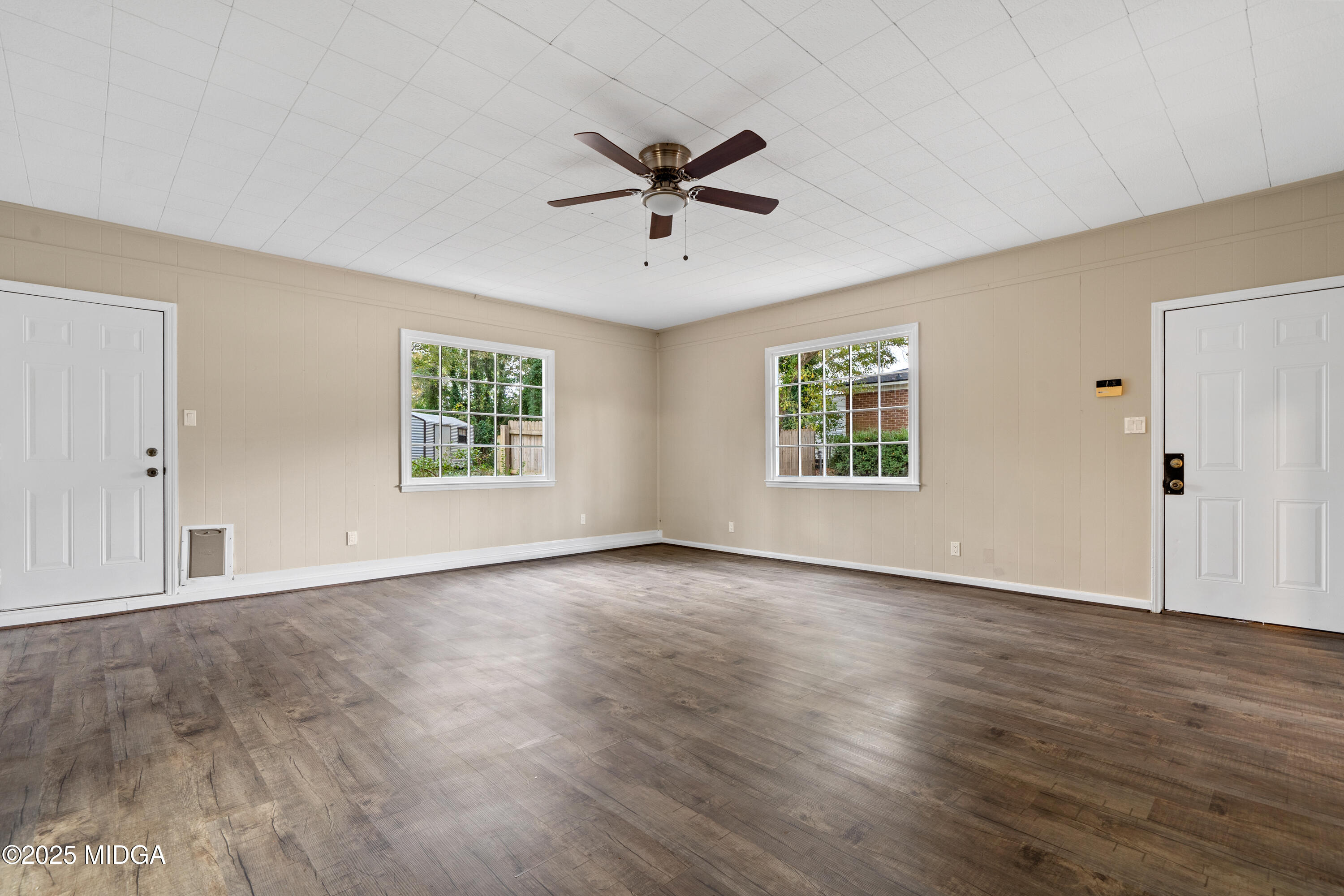 1303 Forest Hill Road Macon, GA 31210 - Photo 25 of 54 an empty room with wooden floor windows and ceiling fan