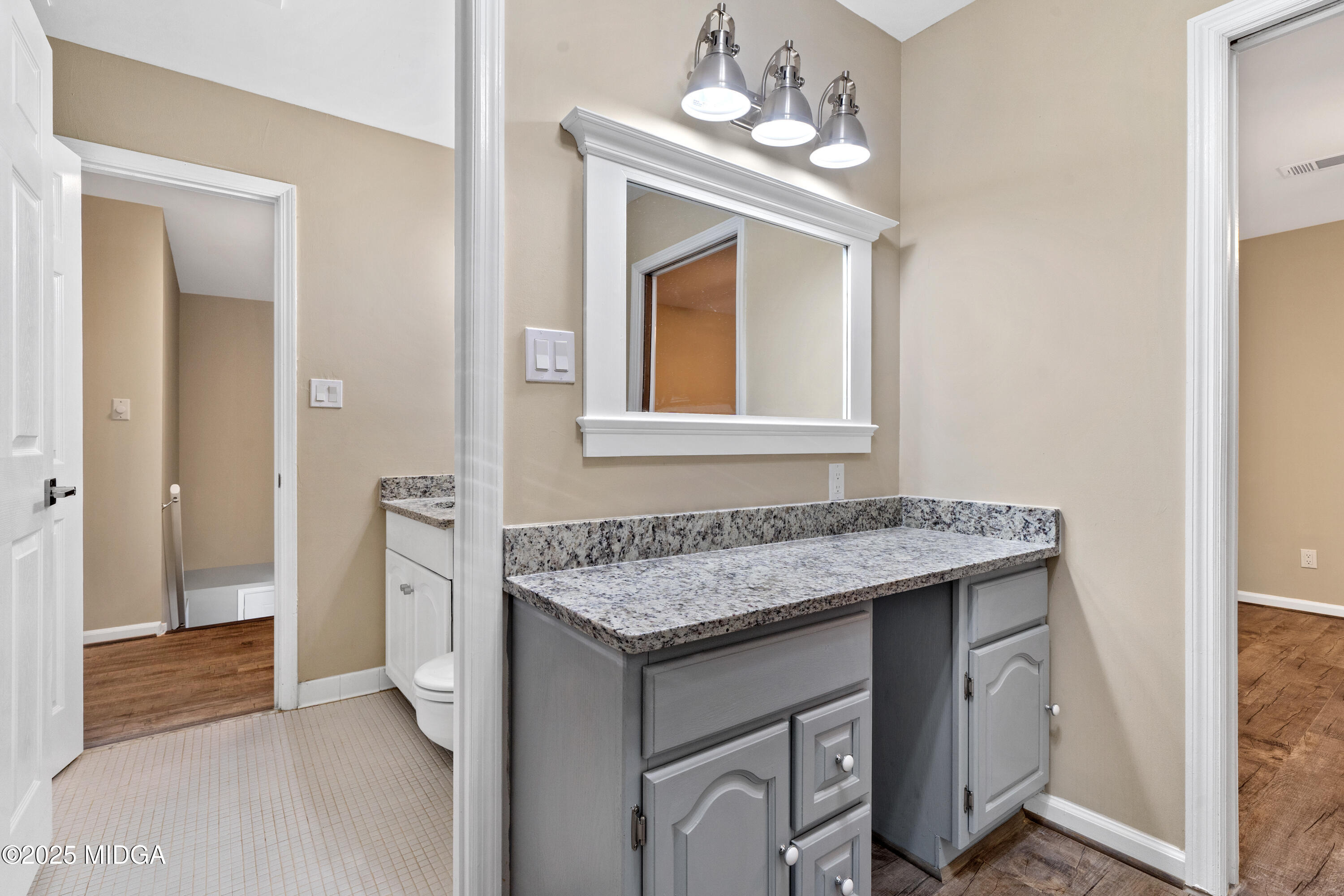 1303 Forest Hill Road Macon, GA 31210 - Photo 36 of 54 a bathroom with a granite countertop sink a vanity and a mirror
