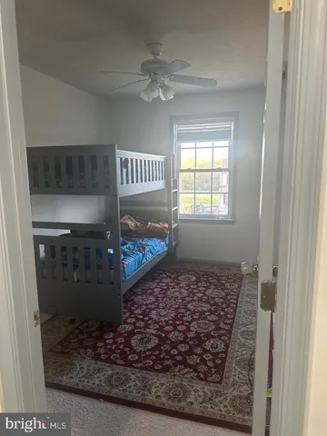 a view of a hallway to a livingroom with furniture wooden floor and a rug