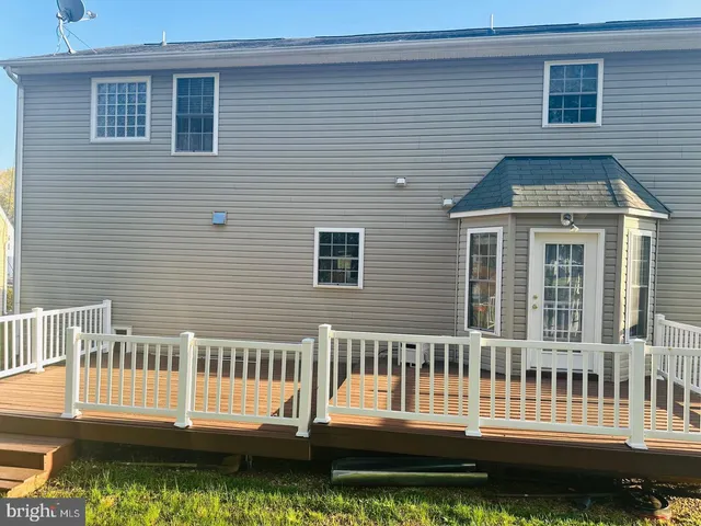 a front view of a house with a yard view and a wooden deck
