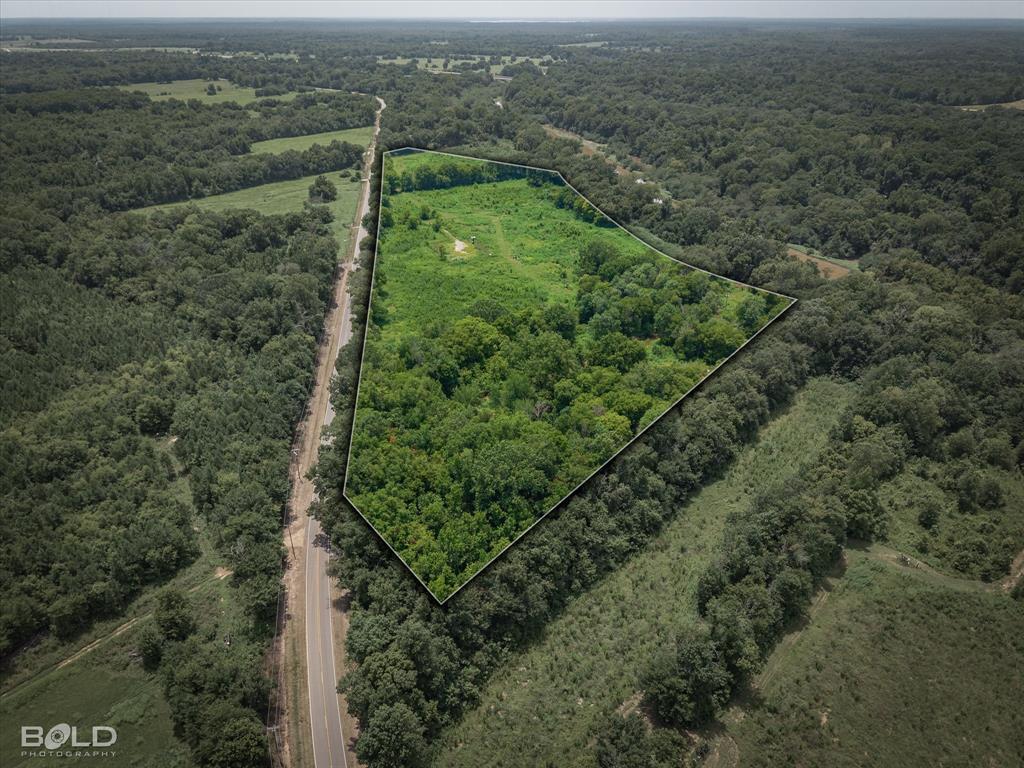 Aerial view of property's location featuring property boundaries highlighted and a heavily wooded area