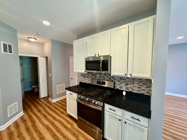 a kitchen with stainless steel appliances granite countertop a stove and a refrigerator