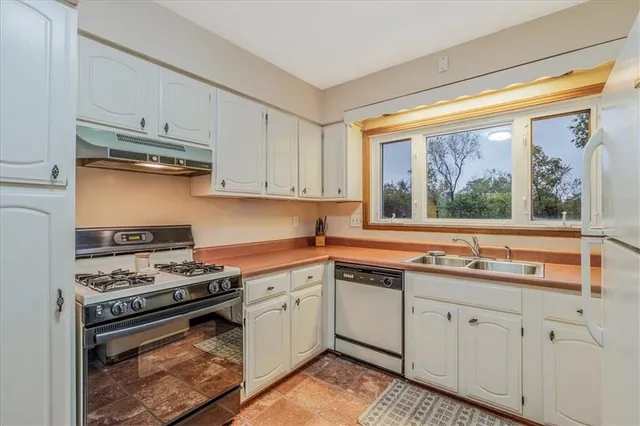 a kitchen with white cabinets and appliances