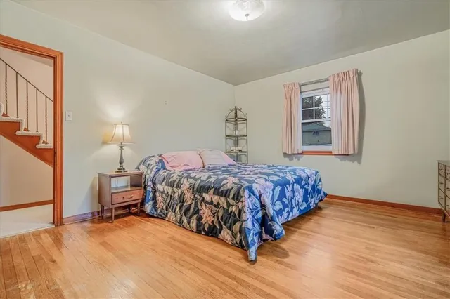 a bedroom with a bed wooden floor and window
