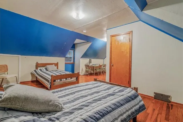 a bedroom with two beds and painting on the wall