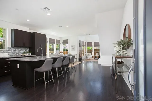 a kitchen with stainless steel appliances granite countertop table chairs stove and granite counter top