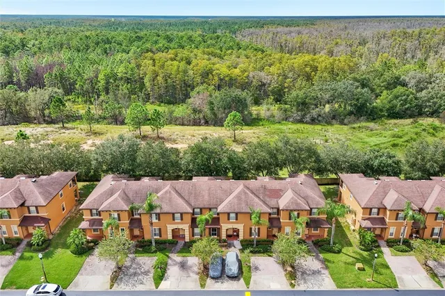 an aerial view of residential houses with yard and green space