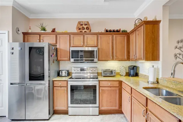 a kitchen with stainless steel appliances granite countertop a sink stove and refrigerator