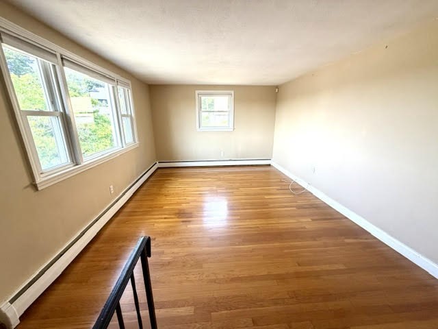 116 Upton Road Waltham, MA 02452 - Photo 8 of 22 a view of an empty room with wooden floor and a window