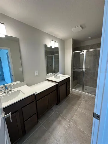 a bathroom with a double vanity sink a mirror and a bathtub