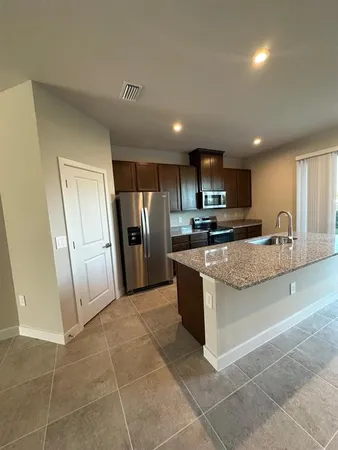 a kitchen with stainless steel appliances granite countertop a stove a sink and a refrigerator