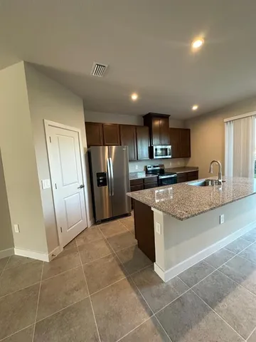 a kitchen with stainless steel appliances granite countertop a stove a sink and a refrigerator