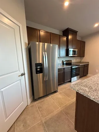 a kitchen with stainless steel appliances granite countertop a refrigerator and a sink