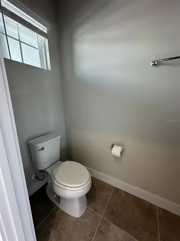 a white toilet sitting next to a window