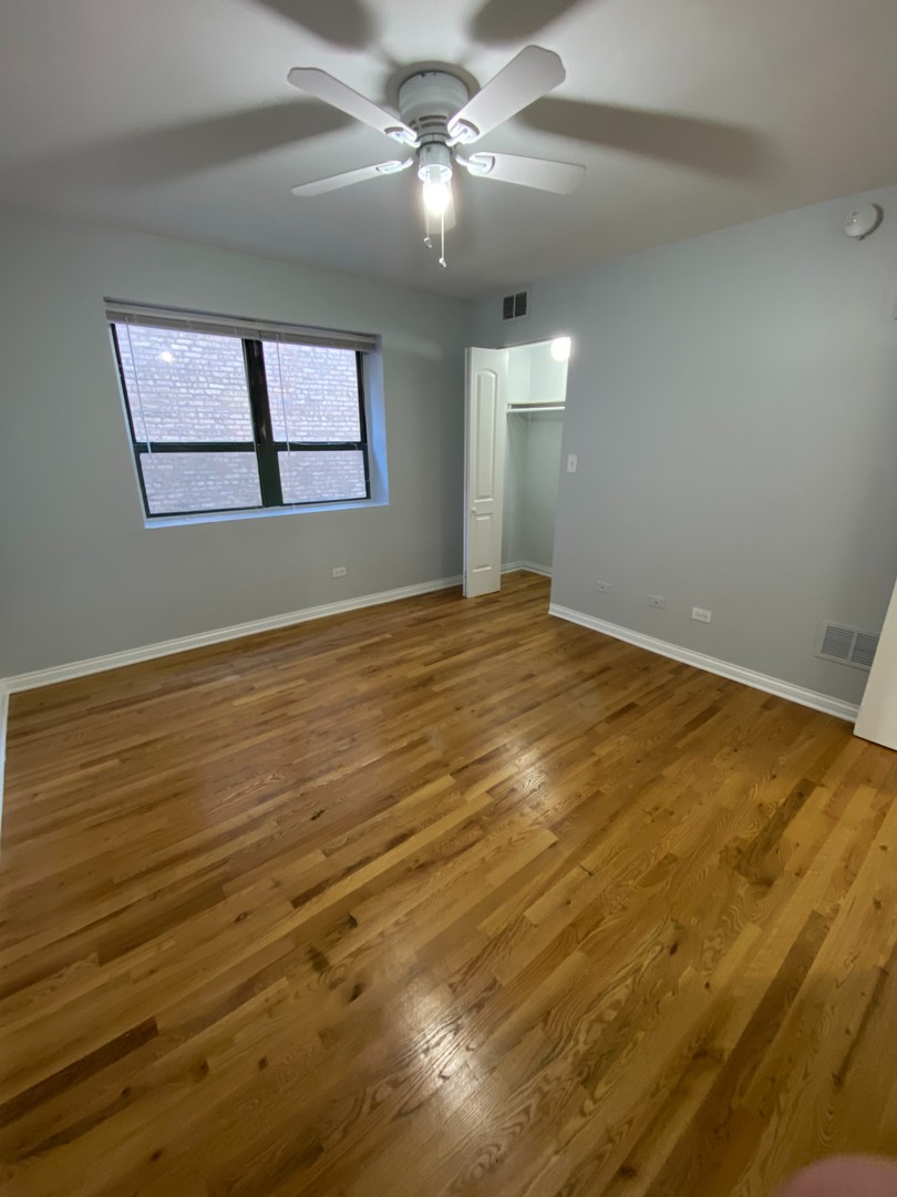 7616 North Marshfield Avenue, Unit 509 Chicago, IL 60626 - Photo 7 of 13 a view of an empty room with window and chandelier fan
